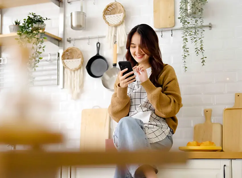 お洒落な自宅でスマホを見ながらリラックスする女性