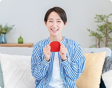 笑顔で財布を持つ女性の写真